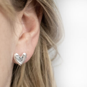 Sterling Silver Molten Heart Studs worn by a model.