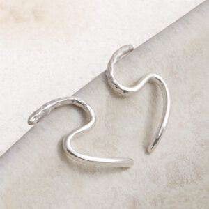 Sterling Silver Swirly Curly Studs on a creamy wavy background.