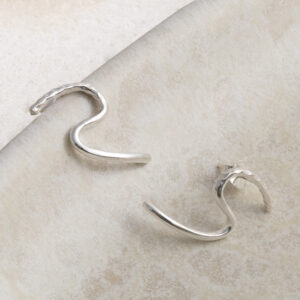 Sterling Silver Swirly Curly Studs on a creamy wavy background.