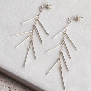 Sterling Silver Dancing Bar Studs on white tile background.