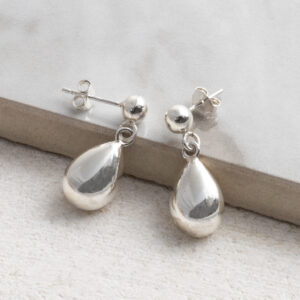 Sterling Silver Rain Drop Studs on a grey tile background.
