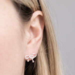 Sterling Silver Bow Studs worn by a model.