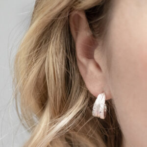 Sterling Silver Feather Hoop Studs on a model.