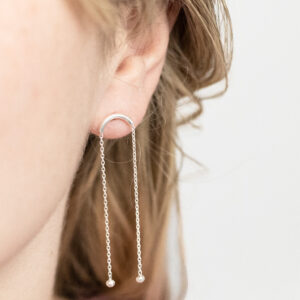 Sterling Silver Curved Bar Studs worn by a model.