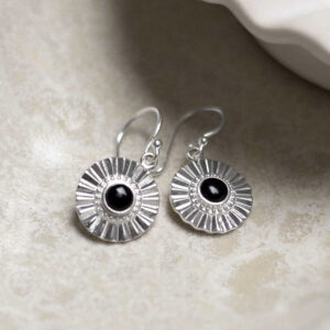 Sterling Silver Onyx Sun Disc Dangly Earrings on stone background