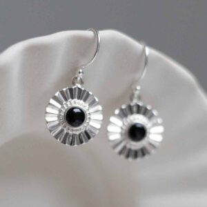 Sterling Silver Onyx Sun Disc Dangly Earrings on jewellery dish