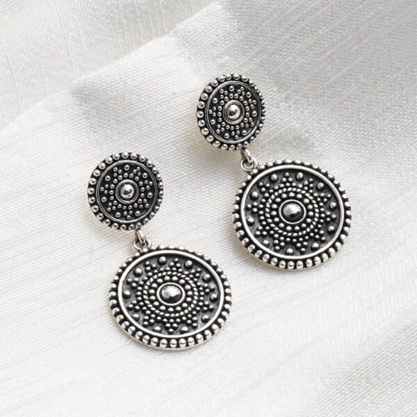 Sterling silver oxidised double Marrakech stud earrings with intricate detailing and a darkened antique finish on a white fabric textured background.