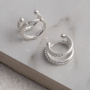 Sterling Silver CZ Double Hoop Huggies on a grey tile background.