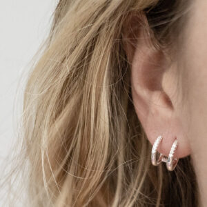 Sterling Silver CZ Double Hoop Huggies worn by a model.