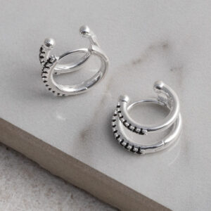 Sterling Silver Black CZ Double Hoop Huggies on a grey tile background.