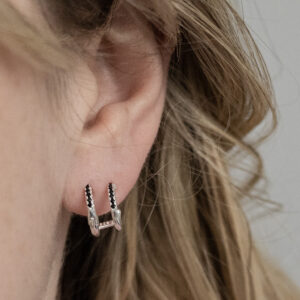 Sterling Silver Black CZ Double Hoop Huggies worn by a model.