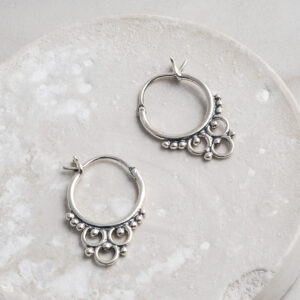 Sterling Silver Tarfaya Hoops featuring a handcrafted detailing on a white circle prop.