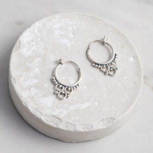 Sterling Silver Tarfaya Hoops featuring a handcrafted detailing on a white circle prop.