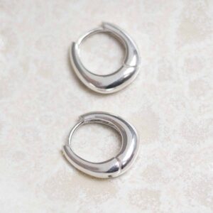 Sterling Silver Oval Huggies on stone background