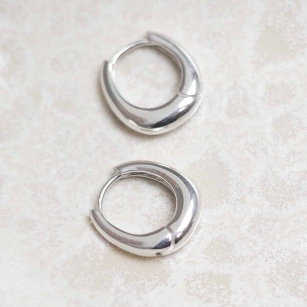 Sterling Silver Oval Huggies on stone background