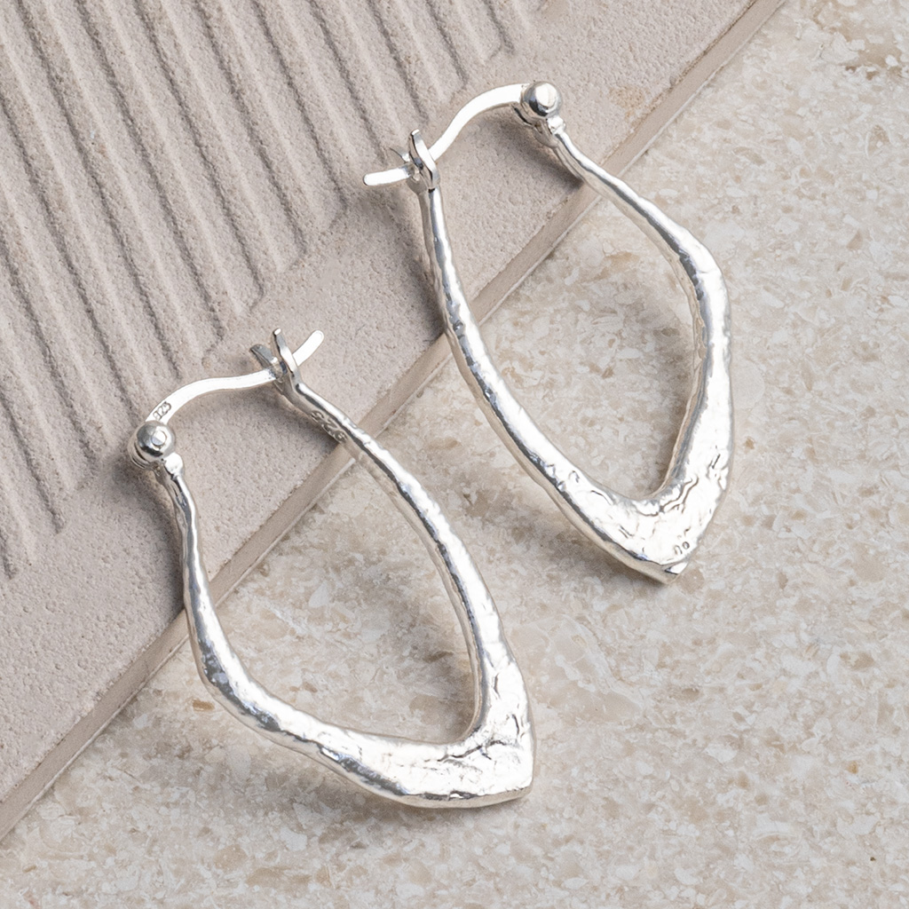 Sterling Silver Molten Hoops on a lined tile background.