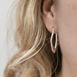 Sterling Silver Molten Hoops worn by a model.