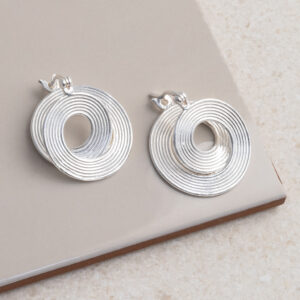 Sterling Silver Twisted Vinyl Hoops on a cream tile background.