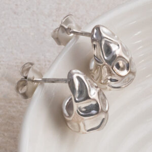 Sterling Silver Molten Drop Studs on white cup background.