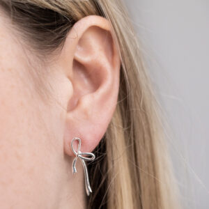 Sterling Silver Ribbon Bow Studs worn by a model.