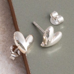 Sterling Silver Love Heart Studs on sage green tile background.