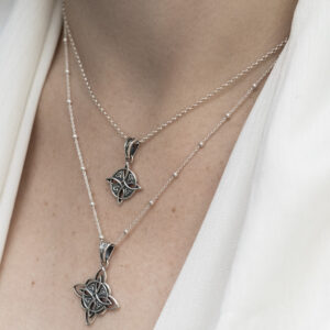 Sterling Silver Witches Necklace in small and large featuring intricate detailing and a oxidised finish on a model.