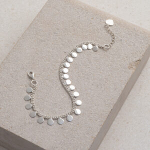Sterling Silver Sequin Charm Bracelet on a cream tile background.