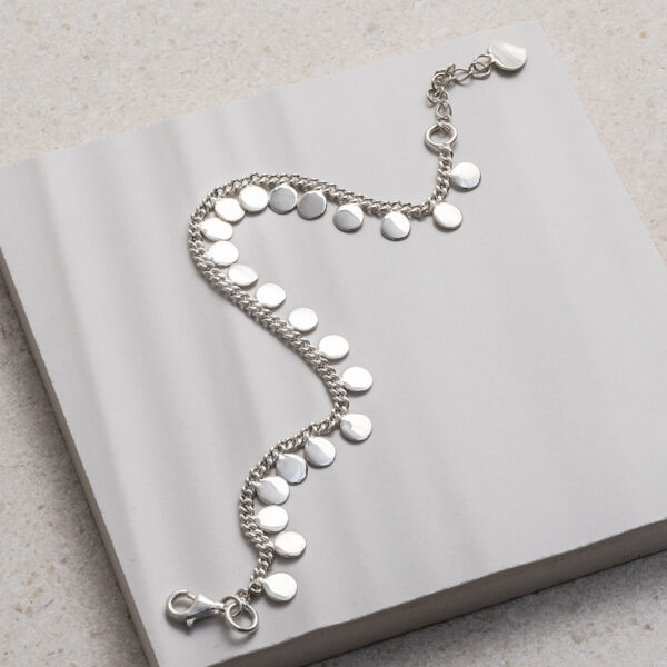 Sterling Silver Sequin Charm Bracelet on a white tile background.