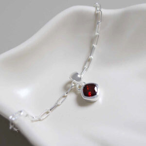 January Sterling Silver Garnet Birthstone Fine Paperclip Bracelet on jewellery dish