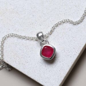 Sterling Silver Ruby Birthstone Necklace on a tile