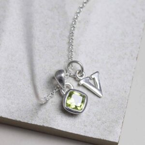 Sterling Silver Peridot Birthstone Necklace on a tile with a letter add on charm