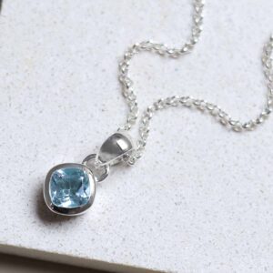 Sterling Silver Blue Topaz Birthstone Necklace on a tile