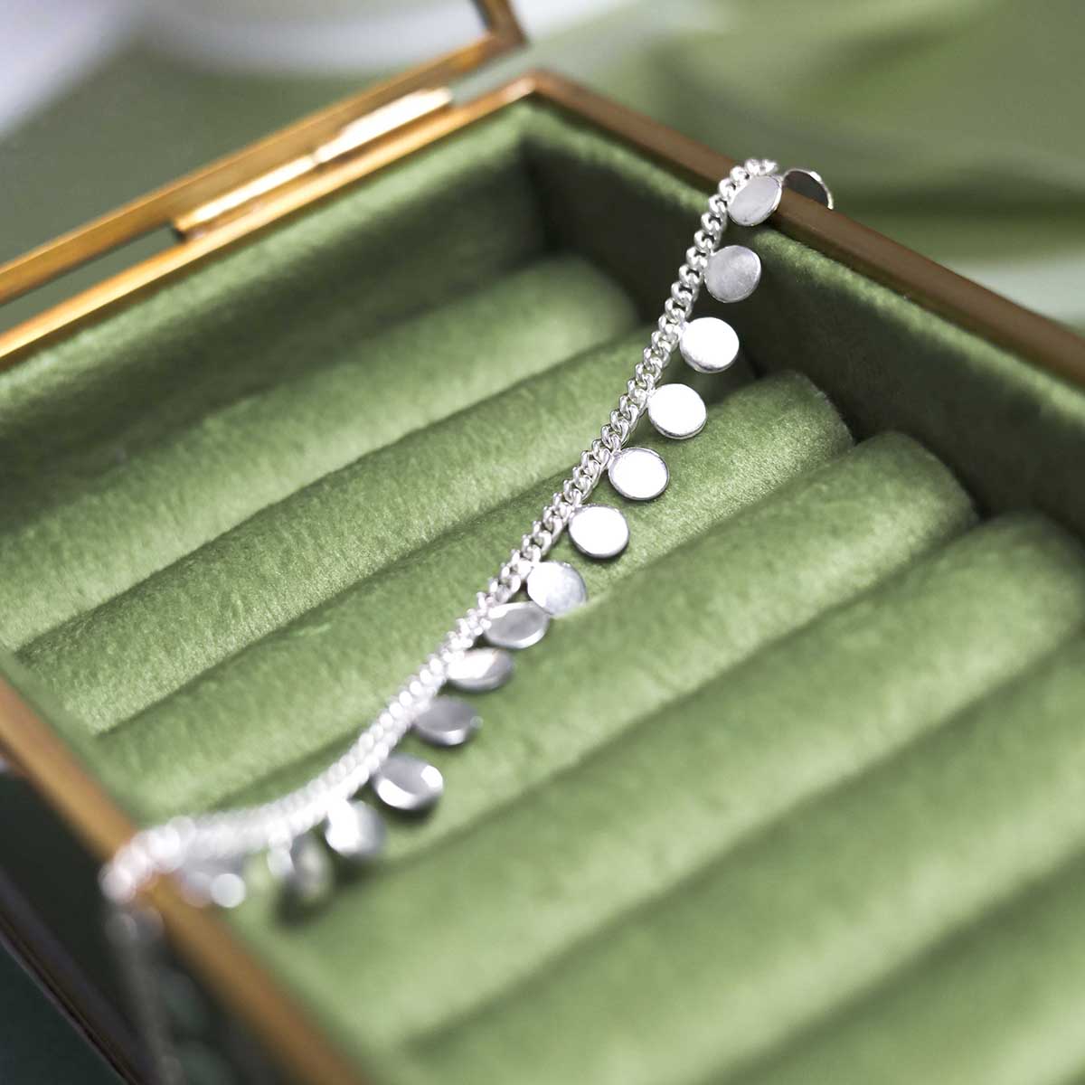 sequin bracelet on green jewellery box