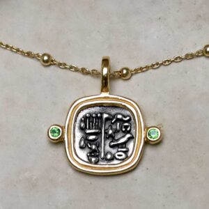 Gold Plated Sterling Silver Hieroglyphics Square Necklace on beige fabric background.