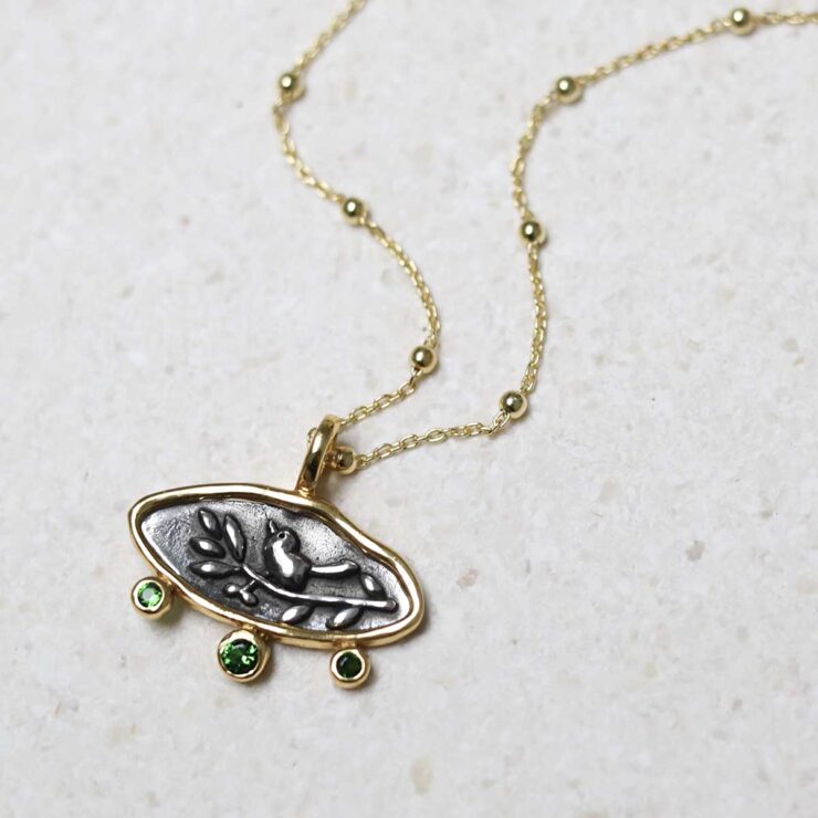 Gold Plated Sterling Silver Hieroglyphics Necklace on beige fabric background.