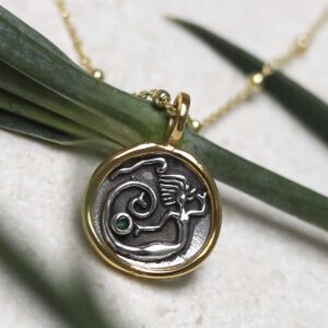 Gold Plated Sterling Silver Mermaid Necklace on beige background with green stem leaf.