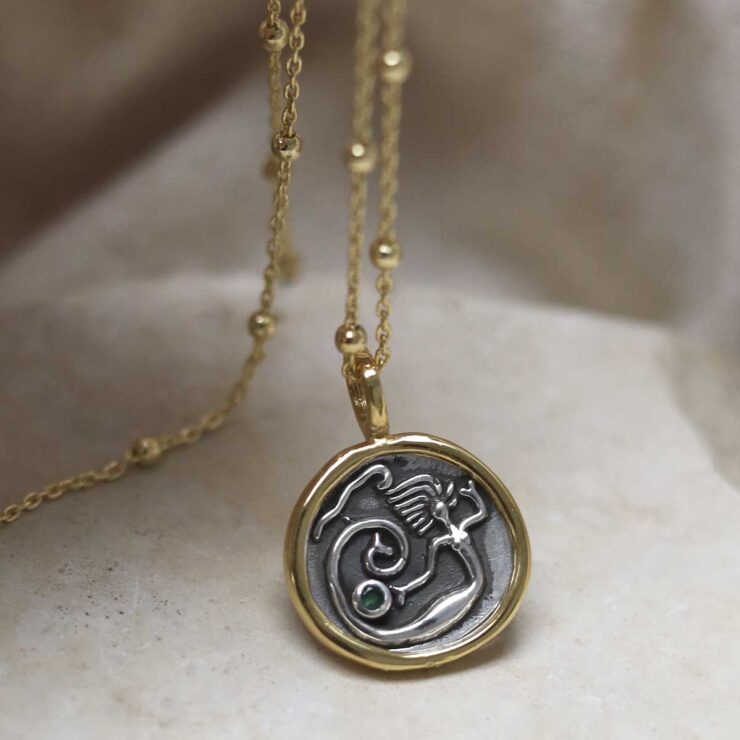 Gold Plated Sterling Silver Mermaid Necklace on beige background