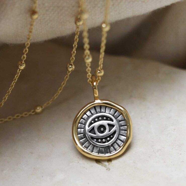 MZB153_Gold Plated Sterling Silver Evil Eye Round Necklace_3 Gold Plated Sterling Silver Evil Eye Round Necklace on beige fabric background.